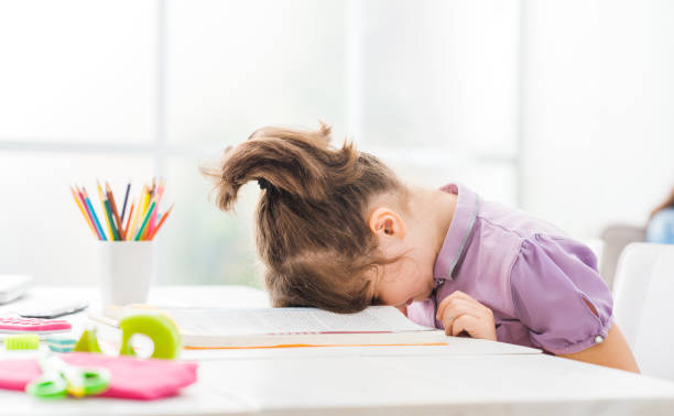 Lazy student girl at home Lazy student girl at home, she is resting with her face down on the school book, education and childhood concept homework books stock pictures, royalty-free photos & images