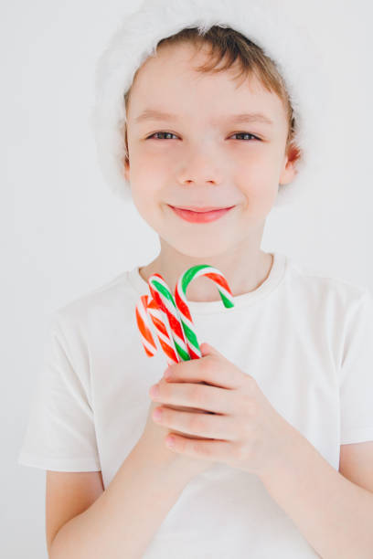 istock Boy in red Santa hat holding a candy cane 862249534