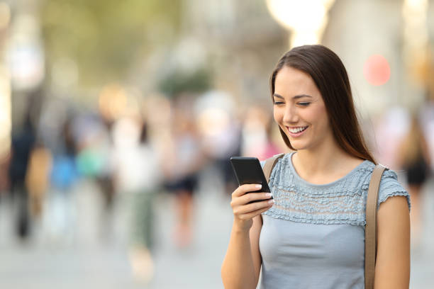 istock Happy lady using a smart phone standing on the street 862249984