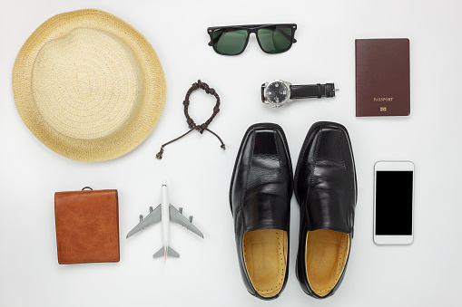 Flat lay of accessories travel and fashion men concept background.Essential items for trip on the white wooden at home office desk.Variety objects for gentlemen adult or teenage and traveler.