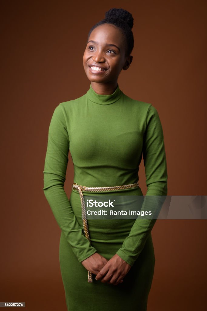 Studio shot of young beautiful African Zulu businesswoman wearing green outfit against colored background Studio shot of young beautiful African Zulu businesswoman wearing green outfit against colored background colored background vertical shot 20-24 Years Stock Photo