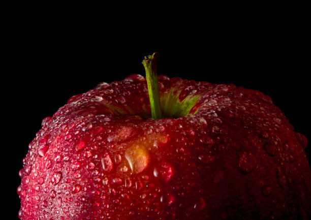 istock Water droplet on glossy surface of red apple on black background 862257306
