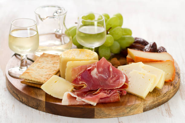 istock prosciutto with cheese and white wine in wooden board on white background 862258500
