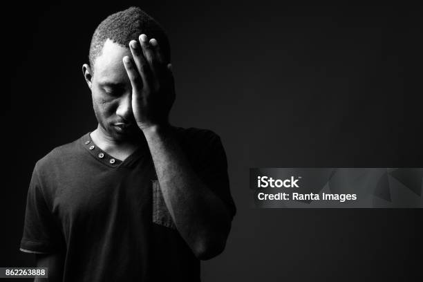 Studio Shot Of Young African Man Wearing Black Shirt In Black And White Stock Photo - Download Image Now
