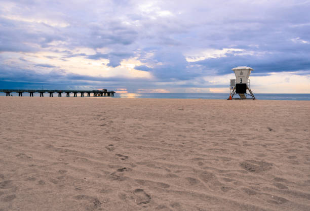 istock footprints in the sand on an empty florida beach on a cloudy summer morning at sunrise between the pier and lifeguard stand 862263966
