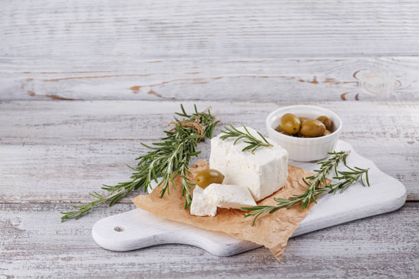 féta fraîches au romarin sur plateau desserte en bois blanc - fetta cheese photos et images de collection