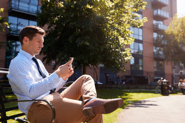 istock Businessman Outdoors Using Mobile Phone On Lunch Break In Park 862274292