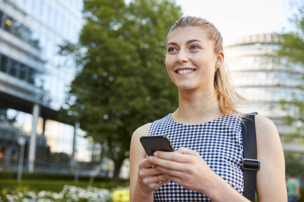 istock Businesswoman Walking To Work In City Looking At Mobile Phone 862277708