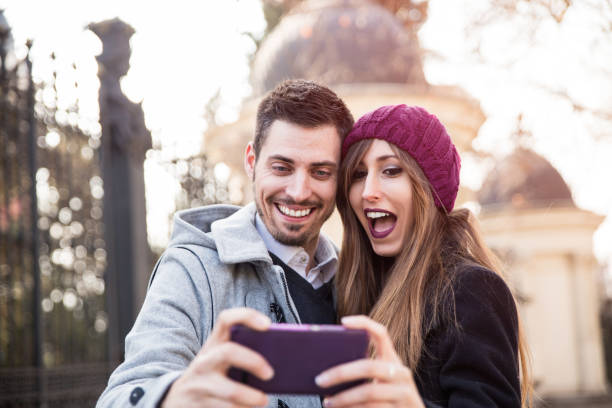 couple taking selfie in the street couple taking selfie with a phone and making silly faces in the street selfie madrid photos stock pictures, royalty-free photos & images