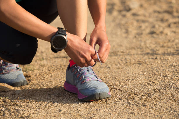 istock woman runner tying shoelace on dirt road 862277762