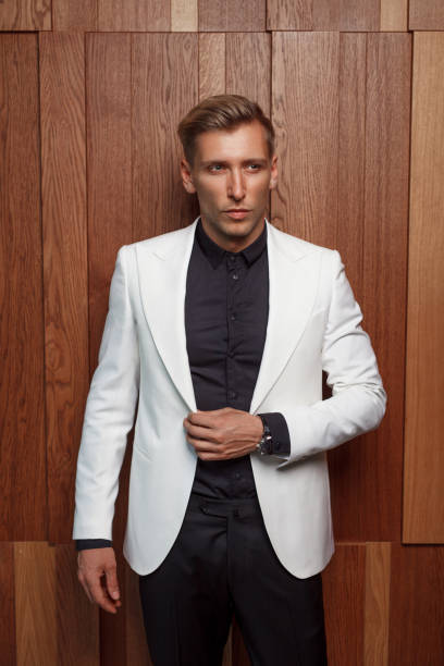 istock Elegant man in suit on wooden wall 862278848