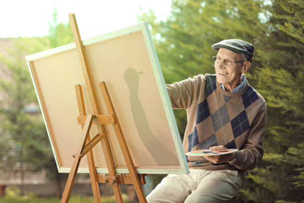 istock Elderly man painting on a canvas outside 862279078