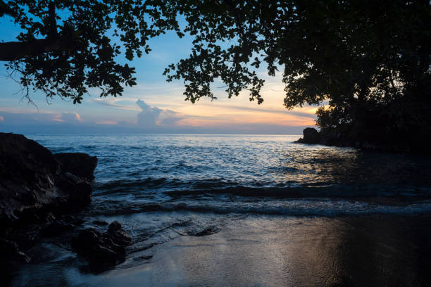The sun sets on a small beach on the volcanic island of Karkar, located in Madang Province, Papua New Guinea.