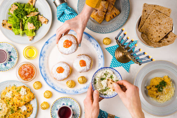 festive feast on hanukkah, table setting, hands over table - latke imagens e fotografias de stock