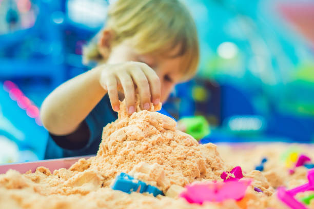 boy playing with kinetic sand in preschool. the development of fine motor concept. creativity game concept - sandbox child human hand sand imagens e fotografias de stock