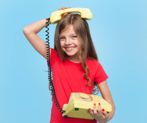 urocza dziewczyna pozowanie z telefonem retro - telephone child isolated on white elegance zdjęcia i obrazy z banku zdjęć