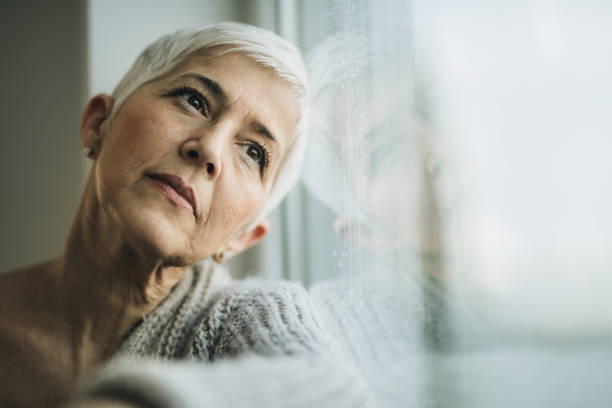 istock Pensive mature woman day dreaming by the window. 862283598