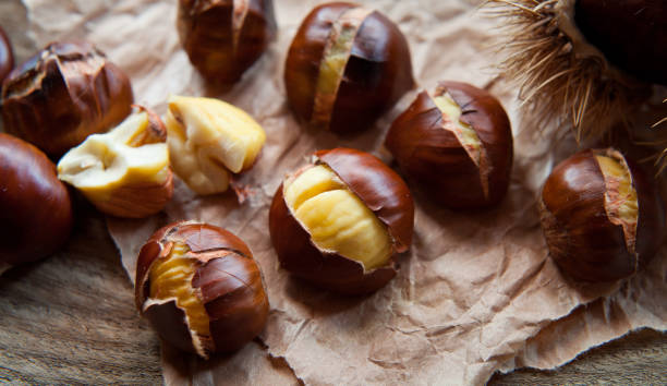 gebratene kastanien zu weihnachten - chestnut stock-fotos und bilder