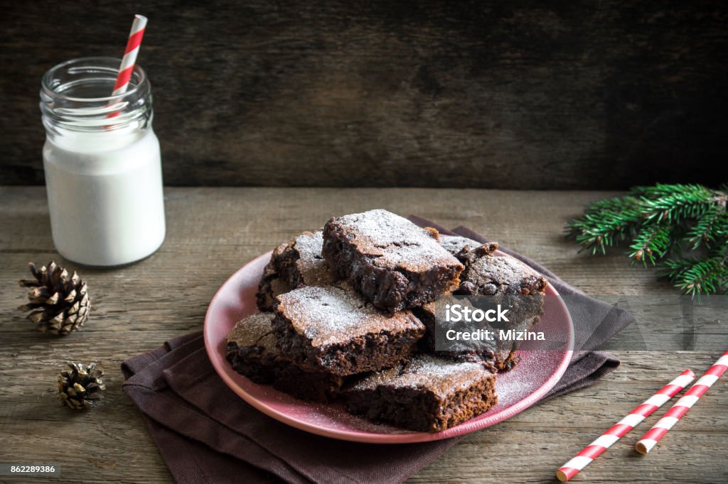 Brownies for Christmas Brownies for Christmas and winter holidays. Homemade chocolate fudge brownies with milk on rustic wooden table. Backgrounds Stock Photo