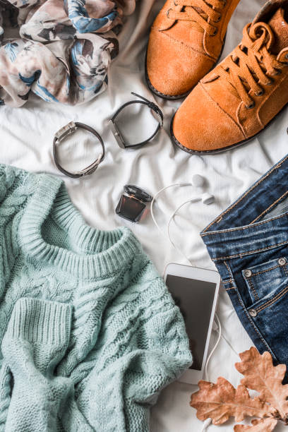 istock Flat lay women's clothing for autumn walks, top view. Brown suede boots, jeans, a blue pullover, scarf, bracelets, watches, headphones, perfume on a light background. Fashion concept 862289508