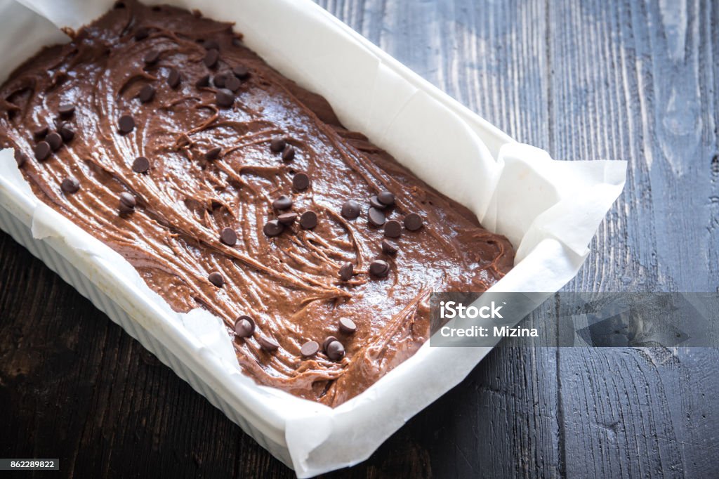brownie or chocolate muffins raw dough Basic homemade brownie or chocolate cake raw dough in baking pan. Cooking (baking) homemade chocolate cake or brownie. Brownie Stock Photo