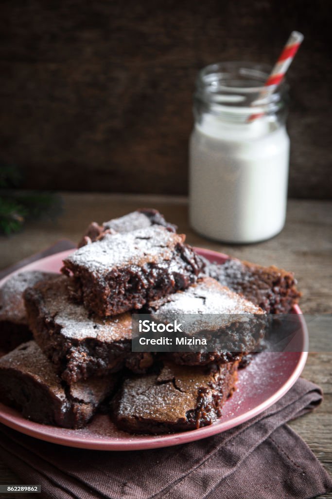 Brownies for Christmas Brownies for Christmas and winter holidays. Homemade chocolate fudge brownies with milk on rustic wooden table. Backgrounds Stock Photo