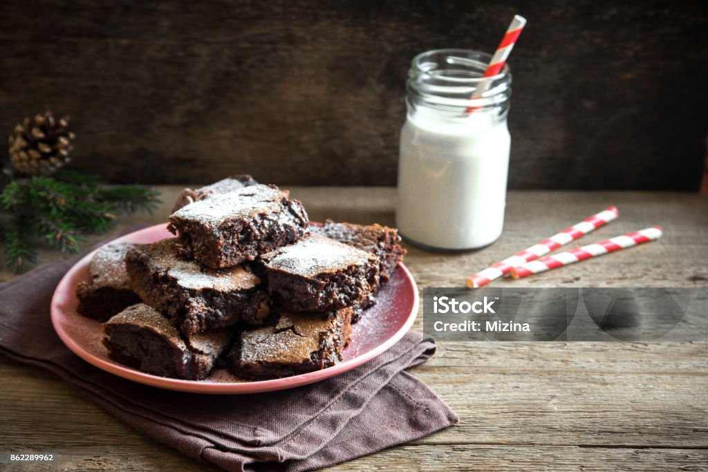 Brownies for Christmas Brownies for Christmas and winter holidays. Homemade chocolate fudge brownies with milk on rustic wooden table. Backgrounds Stock Photo