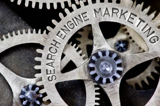 Macro photo of tooth wheel mechanism with SEARCH ENGINE MARKETING concept letters