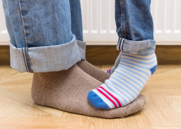 istock Father and son in bright warm socks on a radiator background. 862296660