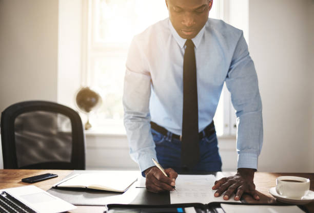 istock Young businessman signing paperwork at his office desk 862298058