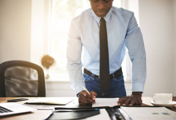 istock Businessman leaning on his office desk signing documents 862298138