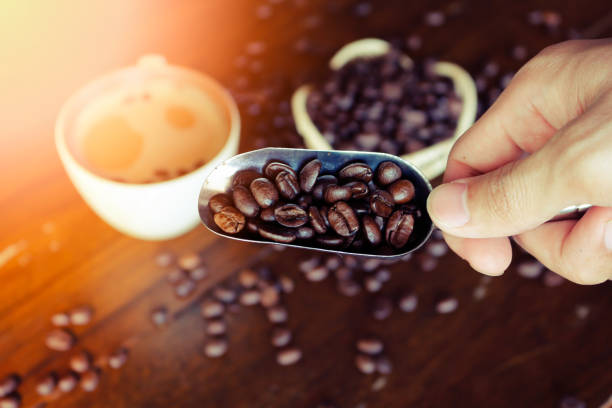 istock Coffee beans on a spoon and Coffee cup on wooden table 862298246