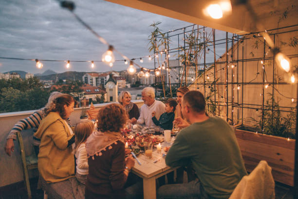 Thanksgiving dinner with family Photo of a multi-generation family having Thanksgiving dinner outdoors on their balcony multi generation family christmas stock pictures, royalty-free photos & images