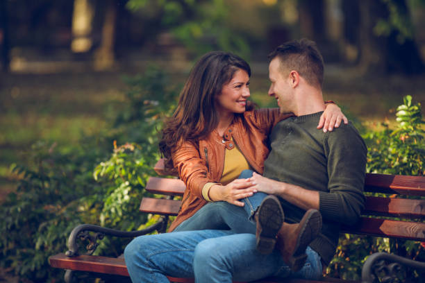 istock Embraced couple sitting on the bench in autumn park 862301636