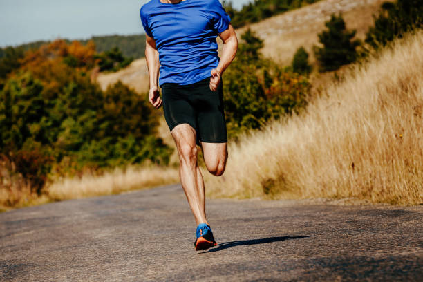 istock muscular athlete men runner running on asphalt road in autumn field 862317954