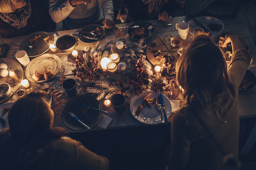 Photo of a multi generation family during Thanksgiving dinner, spending time together over eaten food and messy plates