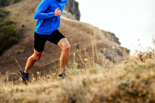 mountain marathon running uphill athlete men runner mountain marathon running uphill athlete men runner sportsman professional sport side view horizontal stock pictures, royalty-free photos & images