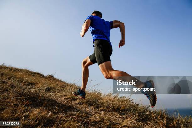 Dinámica Corriendo Cuesta Arriba En Vista Lateral De Camino Hombre Atleta Corredor Foto de stock y más banco de imágenes de Correr