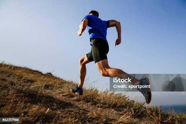 Dynamic Running Uphill On Trail Male Athlete Runner Side View Stock Photo - Download Image Now