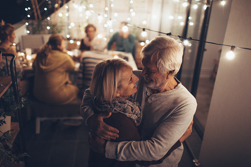 Portrait of a senior couple who celebrates their anniversary at a family dinner, together with their children, grandchildren and friends