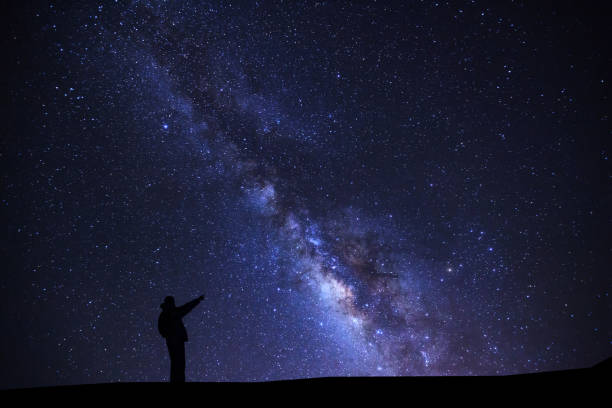 istock A Man is standing pointing on a bright star with milky way galaxy and space dust in the universe 862325474