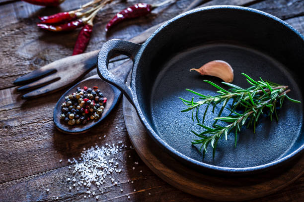 istock Cooking: black cast iron pan with spices and herbs on wooden kitchen table 862325602