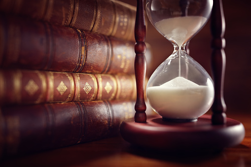 Old books and hourglass in llibrary