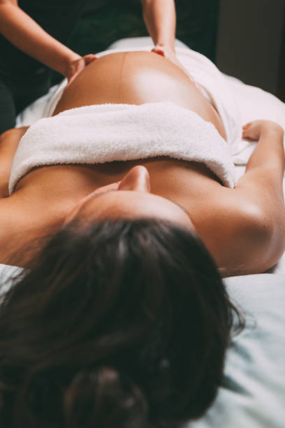 massage pour femme enceinte - abdomen women massaging human hand photos et images de collection