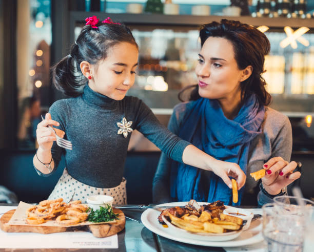 istock Mother and daughter in restaurant 862345352