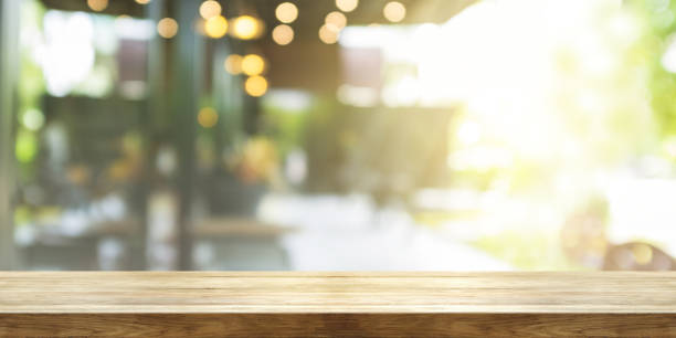 Empty wooden table top with blur coffee shop or restaurant interior background, Panoramic banner. Abstract background can be used product display.