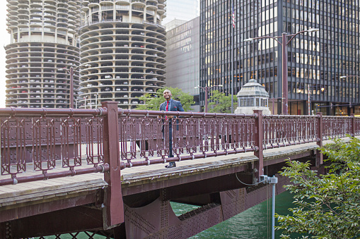 Businessman commuting on a bridge at downtown Chicago, USA.