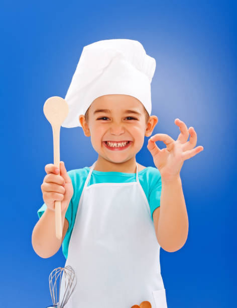 Cheerful little chef showing good taste stock photo