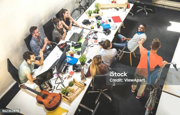 Employee Workers Group Having Fun At Urban Alternative Studio With Young Entrepreneur Coming In With Vintage Bike Business Concept Of Human Resource On Working Time Start Up Internship At Office Stock Photo - Download Image Now