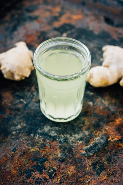 istock ginger juice in small glass jar with ginger root behind. 862370734
